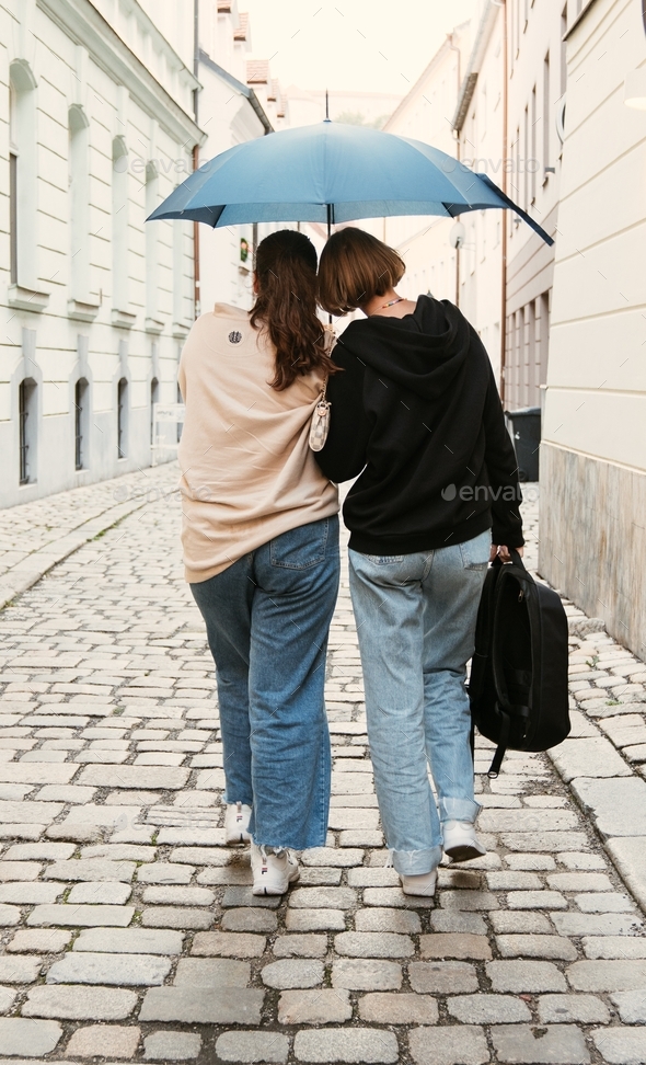 LGBTQ+  couple walking along streets of Bratislava during the rain. Togetherness and equality concep - Stock Photo - Images
