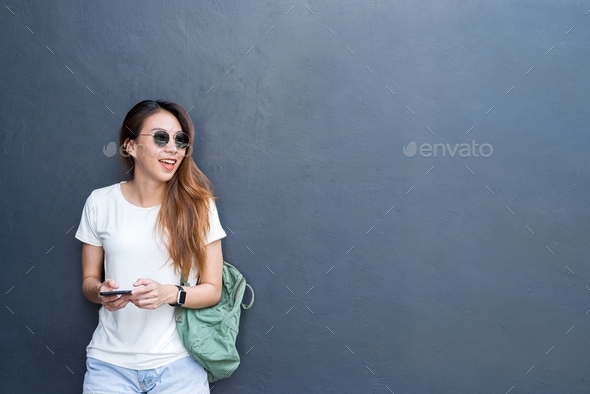 Outdoor lifestyle portrait of pretty sexy young asian girl in travel and glasses style on gray wall - Stock Photo - Images