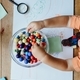 High angle view of a toddler choosing beads from a bowl - PhotoDune Item for Sale