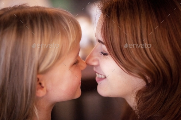 Mom and daughter touched noses to each other and smile