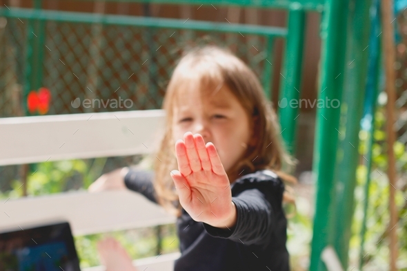 Little girl showing her hand and saying No photo/ No comments
