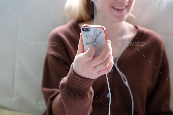 Young woman holding her phone during a zoom call with her friend
