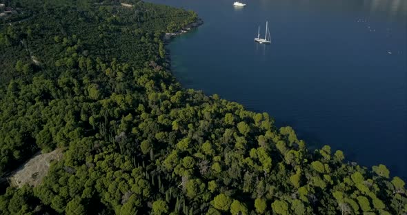 Aerial footage of Dubrovnik Old Town from Lokrum island. the camera rises slowly to reveal a sail bo alt