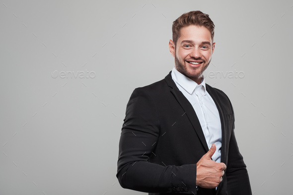 Muscular man in suit showing thumb up