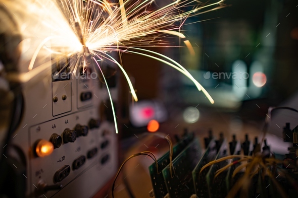 Electronic sparks scatter quickly and sharply from a short circuit on technological equipment