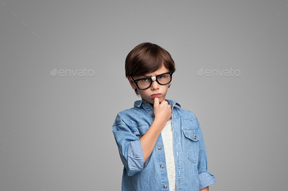 Serious boy in glasses looking at camera