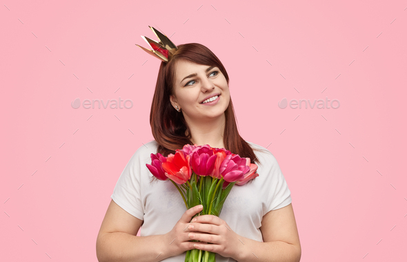 Content plump girl in crown with spring bouquet