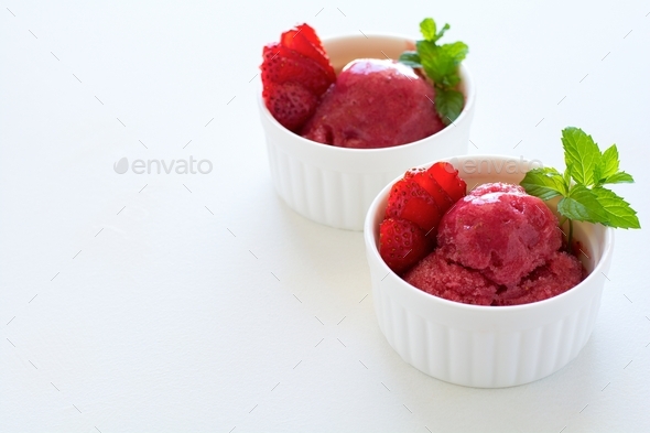 Fruit strawberry sorbet with mint in bowl on white wooden background. Frozen treats