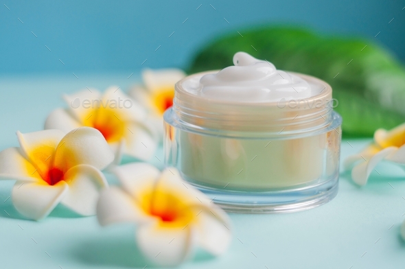 moisturizing cream cosmetics in a jar for skin care with mango flowers