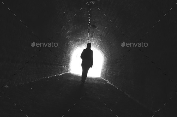 Light at the end of the tunnel with human femal silhouette