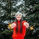 Outdoor portrait of happy cute Latina girl in winter hat and red sweater posing with sparkler  - PhotoDune Item for Sale