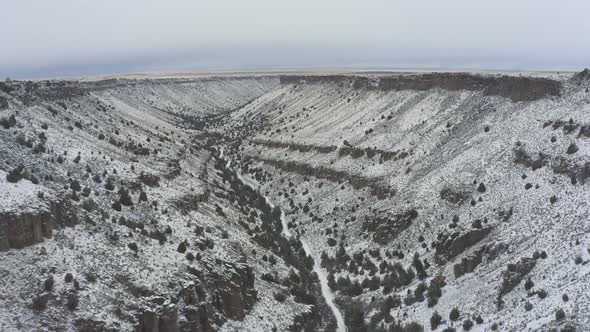 Slow tracking drone shot of snowy canyon alt