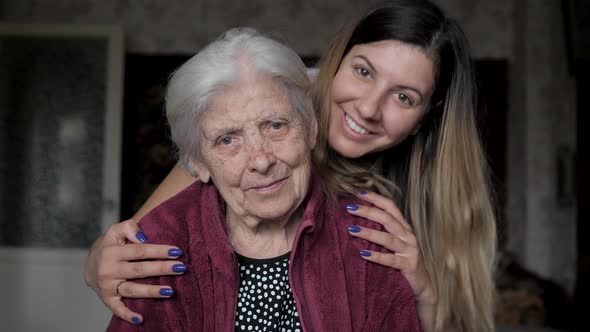 A Woman With A Smile Embraces Her Old Grandmother Portrait alt