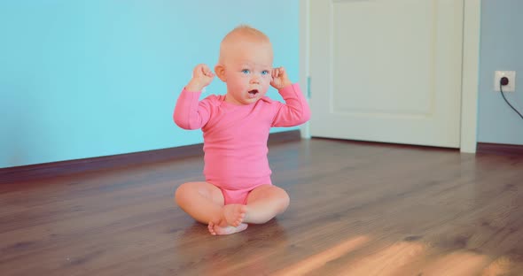 Cute Little Girl Sitting on the Floor at Home alt