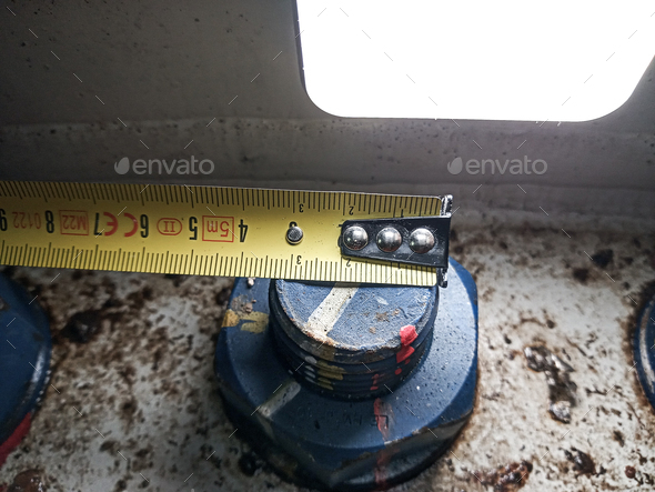 tape measure measuring a screw under a light