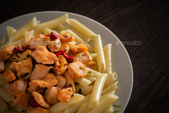 Penne pasta with chicken and vegetables in tomato sauce Stock Photo by