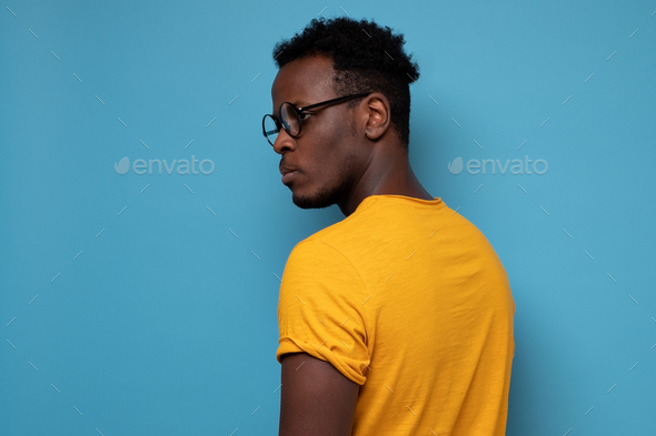 African man in glasses turning back. He is standing alone