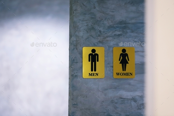 Public restroom men and women sign on gray cement wall texture blur ...