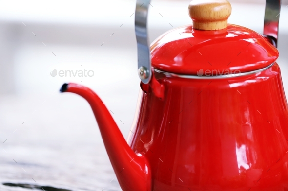 Red kettle enamel tea pot closeup blur background