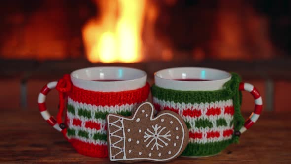 Hot Drinks on Wooden Table over Fireplace Winter Holidays Concept
