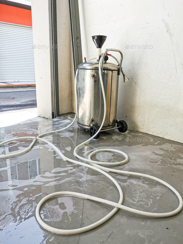 Image of car wash foam machine with hose in the garage. Stock Photo by