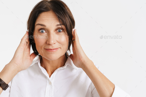 Mature brunette woman expressing surprise while covering her ears Stock ...