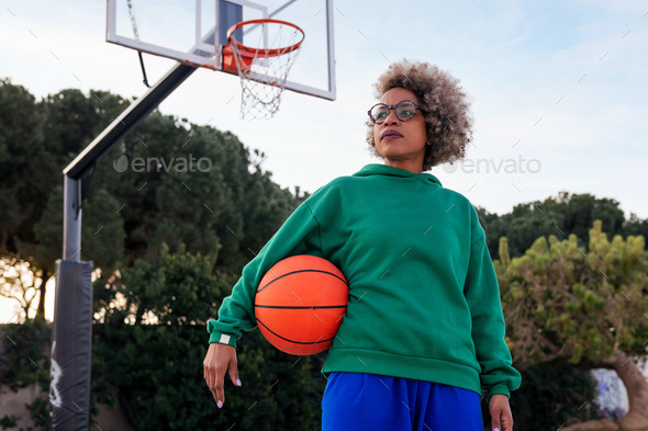 woman with ball under his arm on basketball court