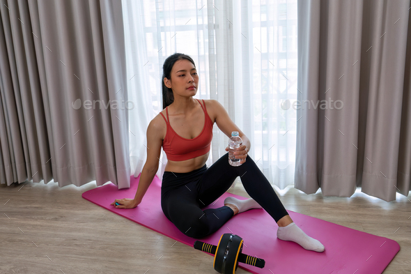 Beautiful lady meditation pilates yoga muscle exercise in the leaving room and drink water