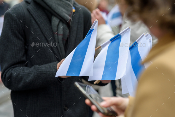 Person holding white-blue-white flags - Stock Photo - Images