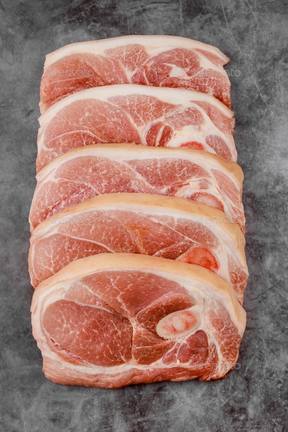 Sliced raw pork shoulder with skin on dark surface. Stock Photo by protastyfood