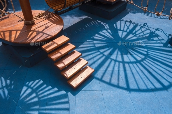 Light and shadow on surface of outdoor playground equipment on rubber tile floor in the park