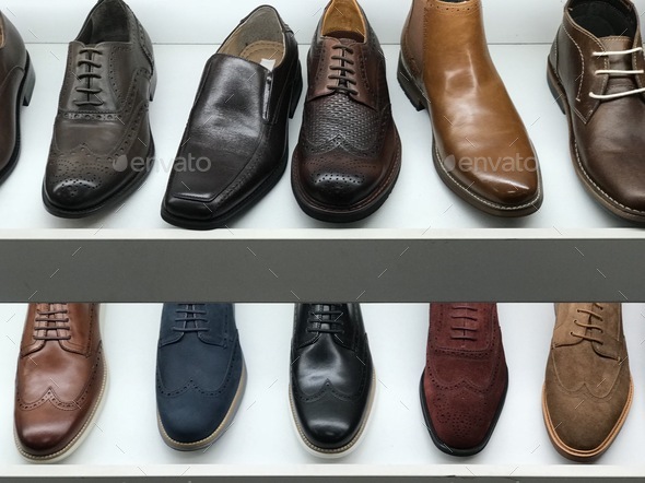 Two rows of men’s shoes are brightly lit Stock Photo by micheledeblock