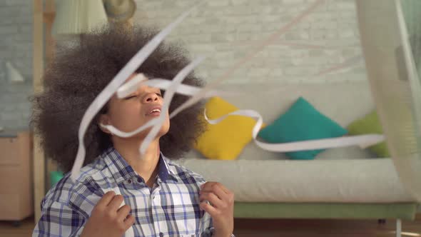 Close Up African Woman with an Afro Hairstyle Escapes From the Heat in Front of a Running Fan alt