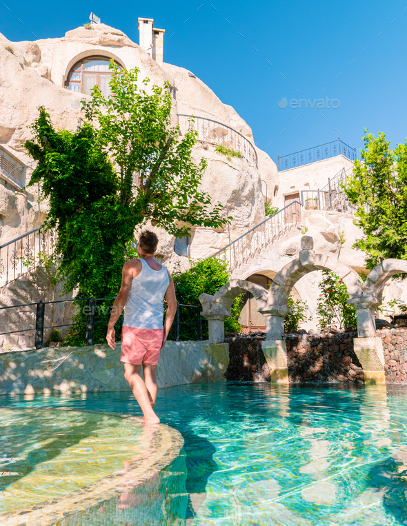 woman in dress at cave house , guy in infinity pool cave house hotel in the mountains of Cappadocia