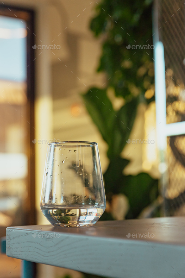 A glass of cool water on the table. Modern blue loft interior restaurant or cafe