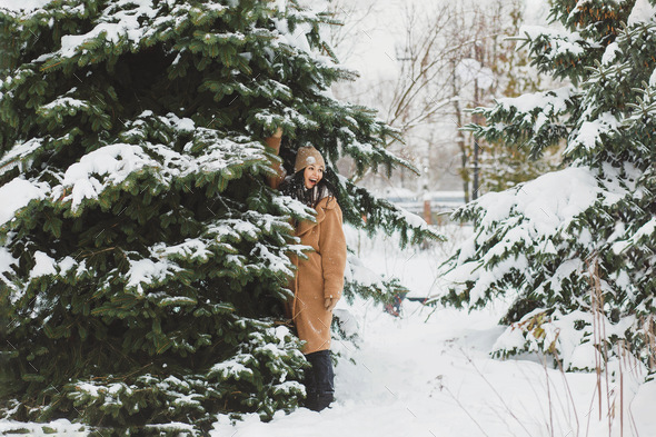 A girl stands under a snow tree and shakes it Stock Photo by Nutka13