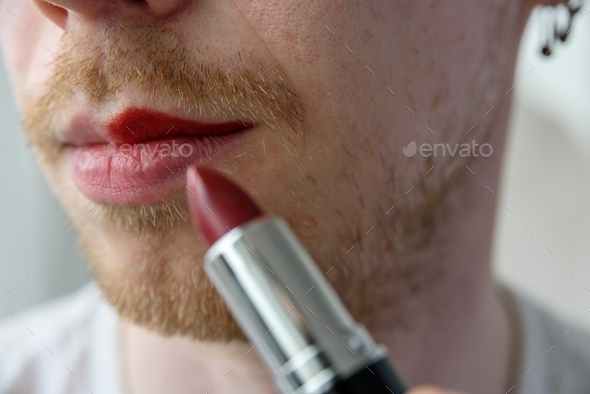 Bearded man applying lipstick - Stock Photo - Images