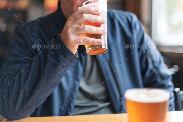 Man drinking a glass of beer at a restaurant