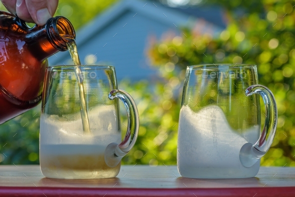 Filling frosty cold mugs with beer from a growler