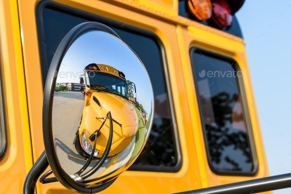 Closeup of school bus reflected in rear view mirror