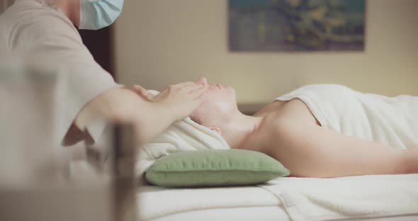 Young Beautiful Caucasian Woman Lying on Spa Bed Get Facial Massage Treatment with Aroma Essential alt