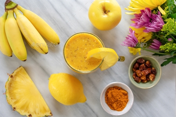 Top view of a yellow smoothie with fresh ingredients, packed with nutrition