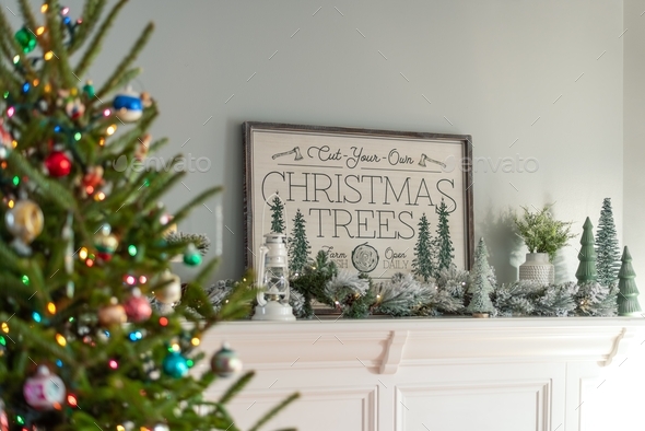 Flocked garland and miniature trees on a white fireplace mantel