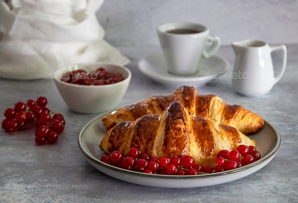 Perfect breakfast - croissants with berries, jam, and coffee.