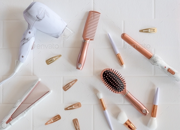 Beautiful modern rose gold hair styling products on a white background