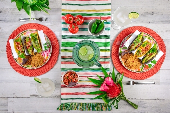 Top view of colorful tabletop with tacos and frozen margaritas