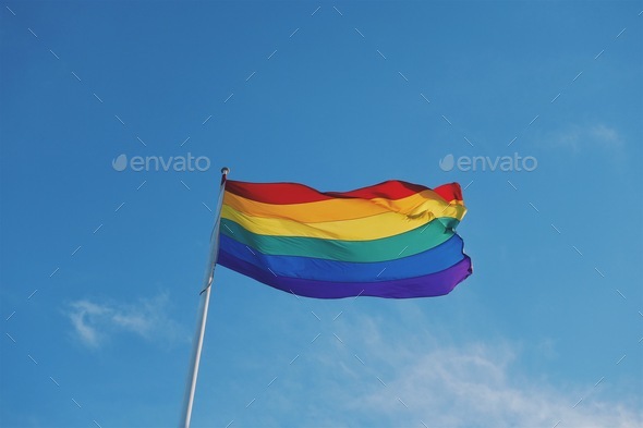 Rainbow flag gay rights marriage equality against blue sky