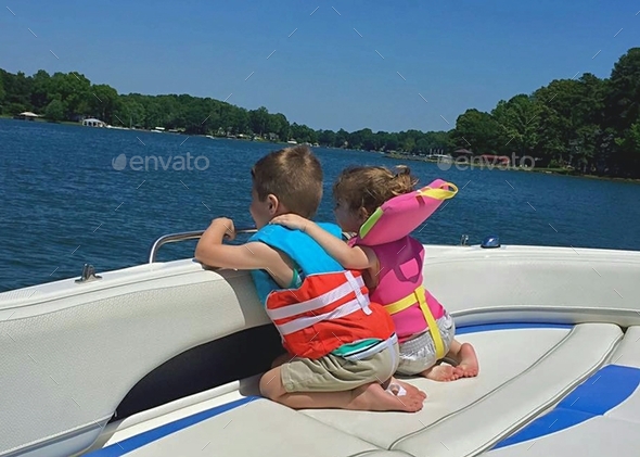 Siblings from behind enjoying a summer boat ride on the lake. Stock ...