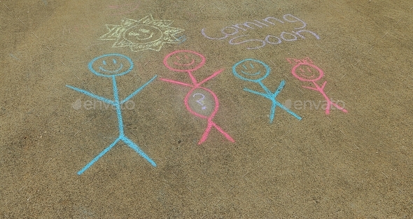 Chalk drawing on sidewalk announcing a new member of the family arriving soon.