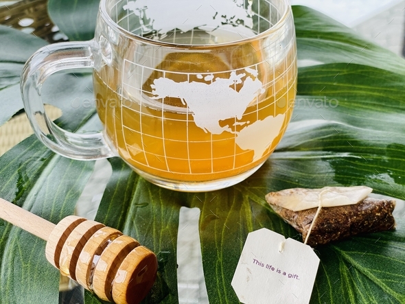 Morning kava tea with honey in glass globe teacup. Reduce stress. Calming vibe. Life is a gift